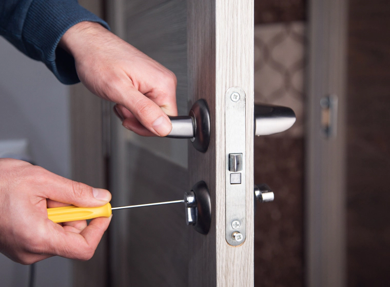 locksmith prying residential door open with tools