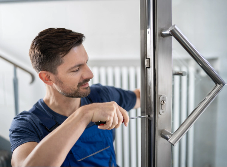 locksmith screwing a bolt into commercial door